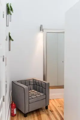 a grey chair in a room with a mirror at GuestReady - Coral Apartment in Porto