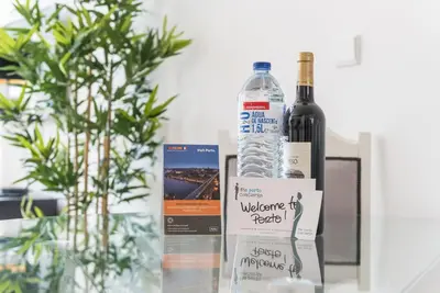 a bottle of wine sitting next to a bottle of alcohol at GuestReady - Coral Apartment in Porto