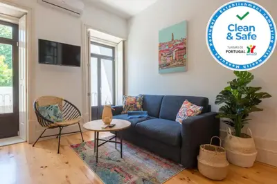 a living room with a blue couch and a table at Sweety Balcony Porto Center in Porto