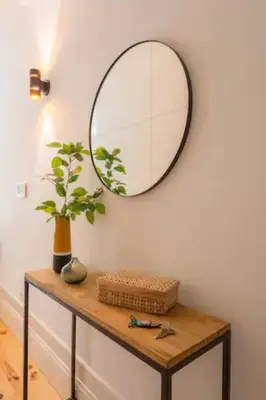 a mirror on a wall above a table with a plant at Sweety Balcony Porto Center in Porto