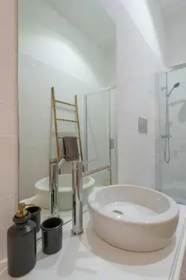 a white bathroom with a sink and a mirror at Sweety Balcony Porto Center in Porto