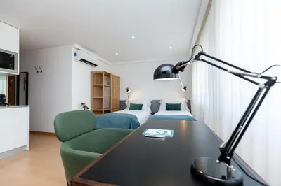a hotel room with a bed and a desk with a lamp at Feel Porto Corporate Housing Marquês in Porto