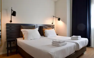 a bedroom with two beds with white sheets and pillows at Spot Apartments in Porto