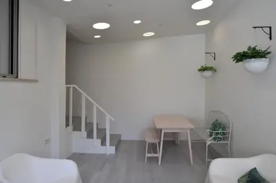a living room with a table and chairs and stairs at Spot Apartments in Porto