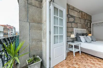a bedroom with a stone wall with a large bed at GuestReady - Grandeur River Balcony Reborn in Porto