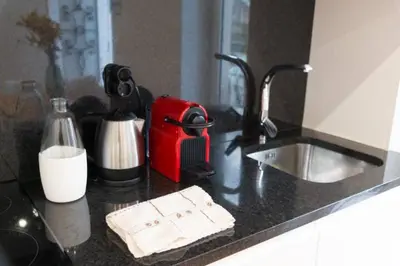 a kitchen counter with a sink and a red appliance at Warmly Porto in Porto