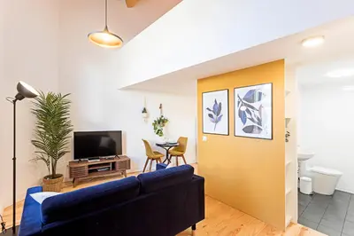 a living room with a blue couch and a tv at Vila Burgães by LovelyStay in Porto