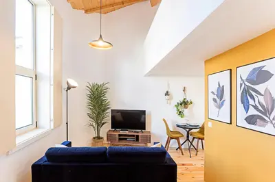 a living room with a blue couch and a tv at Vila Burgães by LovelyStay in Porto
