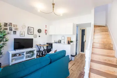 a living room with a blue couch and a kitchen at Vila Burgães by LovelyStay in Porto
