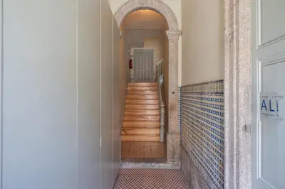 a hallway with stairs and an archway in a building at History Porto in Porto