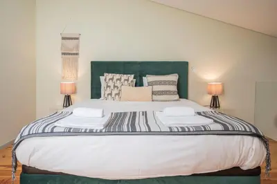 a bedroom with a large bed with two lamps at History Porto in Porto