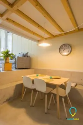 a table and chairs in a room with a clock on the wall at Pretty Porto in Porto