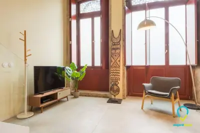 a living room with a television and a chair at Pretty Porto in Porto