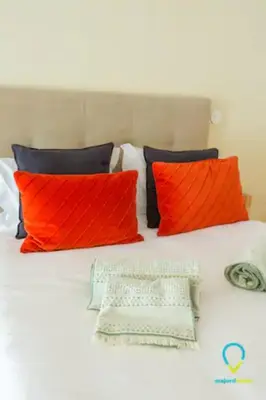 a bed with orange and black pillows on it at Pretty Porto in Porto