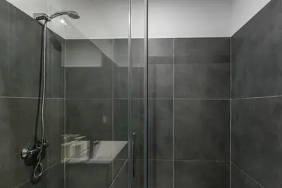a bathroom with a shower with a glass door at GuestReady - Wellspring Bloom in Porto