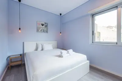a white bedroom with a large white bed and a window at GuestReady - Wellspring Bloom in Porto