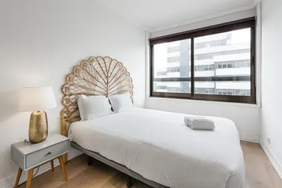 a white bedroom with a large bed and a window at GuestReady - Mystic Subdual in Porto