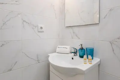 a white bathroom with a sink and a mirror at GuestReady - Mystic Subdual in Porto