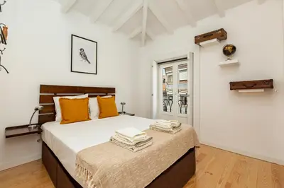 a bedroom with a large bed with orange pillows at Virtudes River Views by Porto City Hosts in Porto