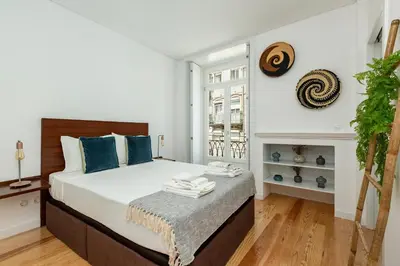 a bedroom with a large bed with blue pillows at Virtudes River Views by Porto City Hosts in Porto
