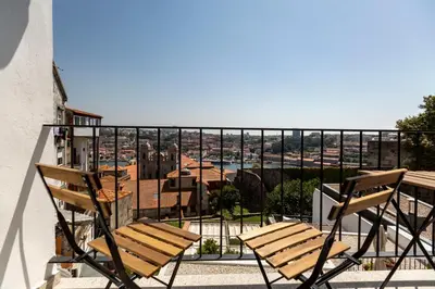 a pair of chairs sitting on a balcony with a view at Virtudes River Views by Porto City Hosts in Porto