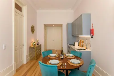 a kitchen and dining room with a table and chairs at LovelyStay - 2BR Flat with AC in Duque de Loulé in Porto
