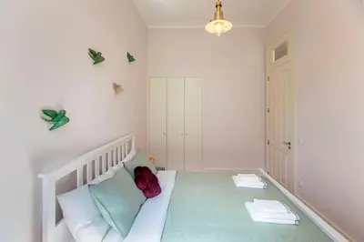 a bedroom with a white bed with a red stuffed animal on it at LovelyStay - 2BR Flat with AC in Duque de Loulé in Porto
