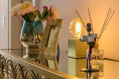 a glass table with flowers and a vase on it at LovelyStay - 2BR Flat with AC in Duque de Loulé in Porto