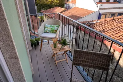 a balcony with a chair and a table with plants at Jasmine Loft in Porto