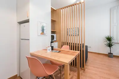 a kitchen and dining room with a wooden table and chairs at GuestReady - Yazdah Flat 3 in Porto