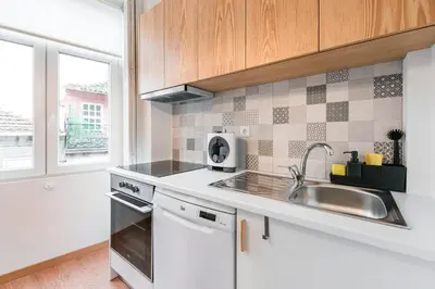 a white kitchen with a sink and a window at GuestReady - Yazdah Flat 3 in Porto