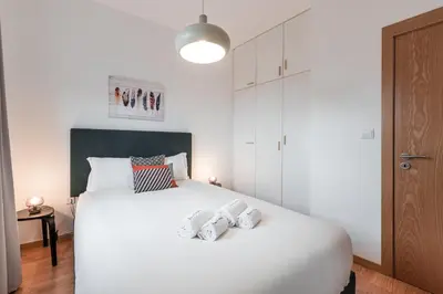 a bedroom with a large white bed with two pillows at GuestReady - Yazdah Flat 3 in Porto
