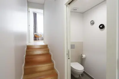 a small bathroom with a toilet and a stairway at HM - Vagus Oporto House in Porto