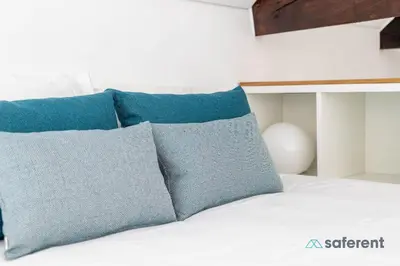 a bed with blue pillows on top of it at Flores - Delight Loft Porto - Next to Ribeira in Porto