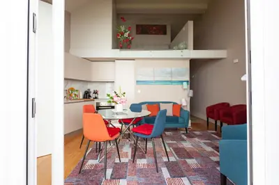 a kitchen and living room with a table and chairs at Oporto City View - Flora Garden in Porto