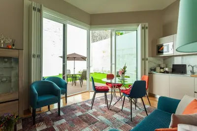 a kitchen and living room with a table and chairs at Oporto City View - Flora Garden in Porto