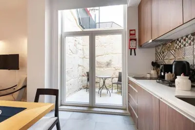 a kitchen with a large window and a table at TMH Torrinha in Porto