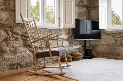 a wooden rocking chair in a room with a tv at Oporto Swimming Pool House in Porto