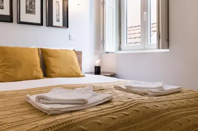 a bed with two towels sitting on top of it at Oporto Swimming Pool House in Porto