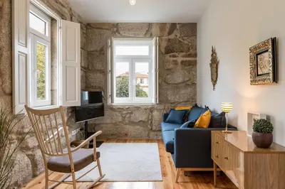 a living room with a blue couch and a chair at Oporto Swimming Pool House in Porto