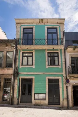 a green building with a balcony on a street at Oporto Swimming Pool House in Porto