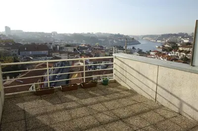 a balcony with potted plants and a view of a city at Porto River Sunset 1st in Vila Nova de Gaia