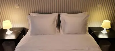 a bed with white sheets and pillows and two lamps at VIVER D'AMOR Oporto Douro River Flat in Vila Nova de Gaia