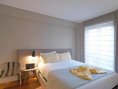 a bedroom with a large white bed with a window at New Oporto Apartments - São Bento in Porto