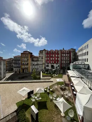 a courtyard with tables and umbrellas in a city at New Oporto Apartments - São Bento in Porto
