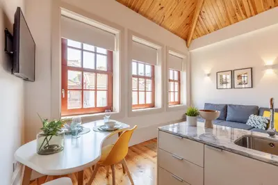 a kitchen with a white table and chairs and a couch at D&S - Falling Leaves in Porto