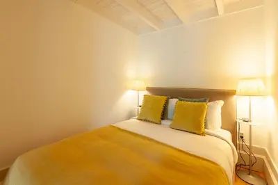 a bedroom with a large bed with yellow pillows at D&S - Falling Leaves in Porto