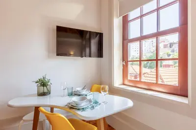 a dining room with a white table and a window at D&S - Falling Leaves in Porto