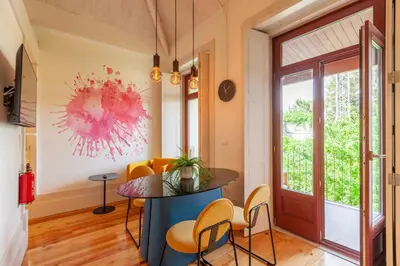 a room with a table and chairs and a window at D&S - Falling Leaves in Porto