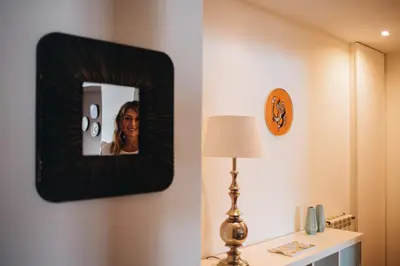 a woman is taking a picture in a mirror in a room at Douro Riverfront 2BR with Private Terrace & Garage in Porto